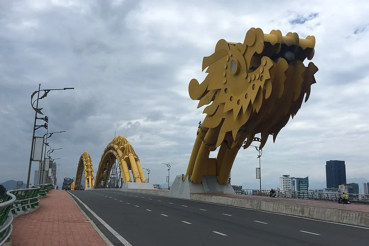 The golden dragon head of the bridge over the road, photographed in daylight