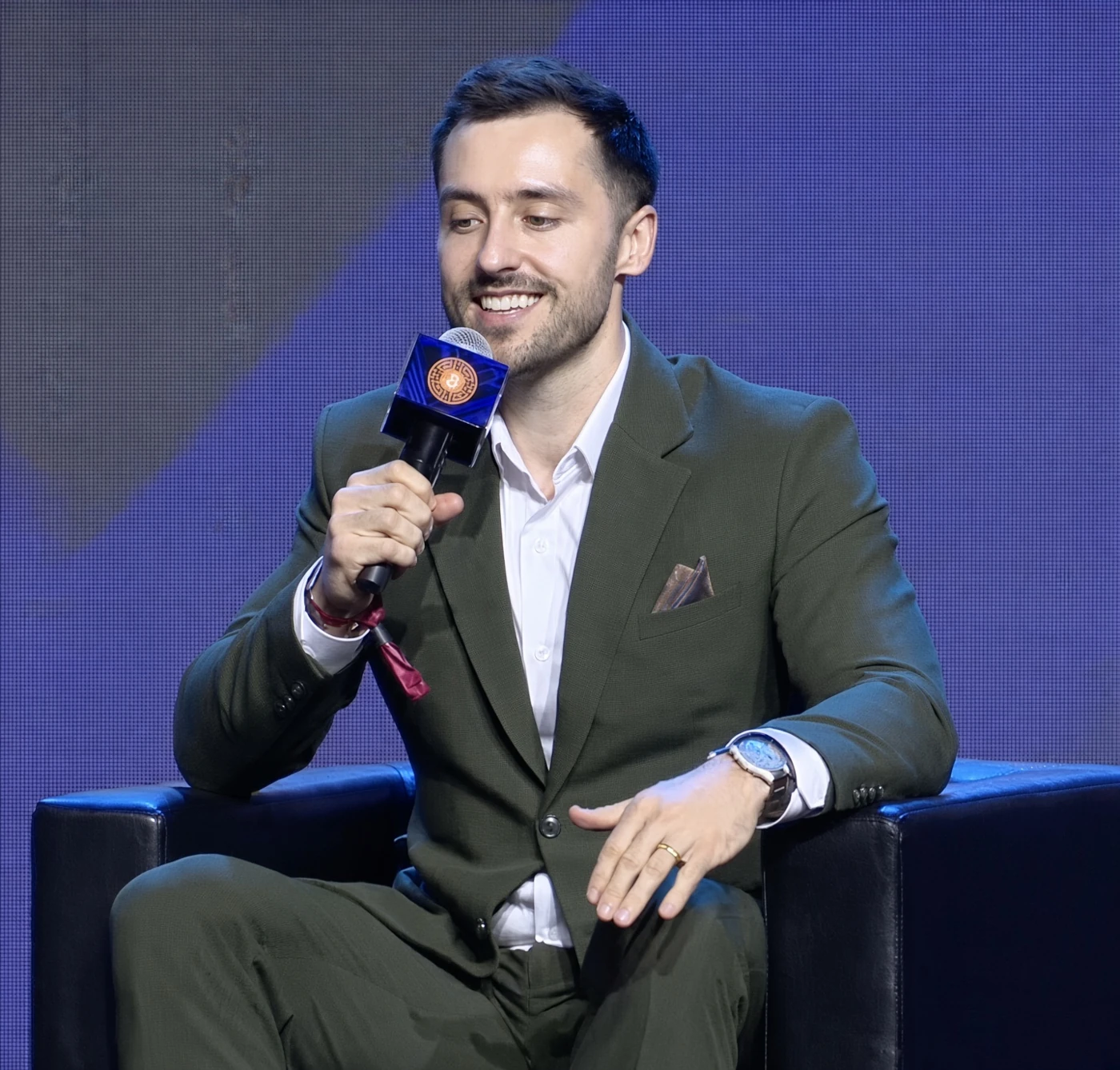 Jake smiling and holding a microphone during a conversation on stage