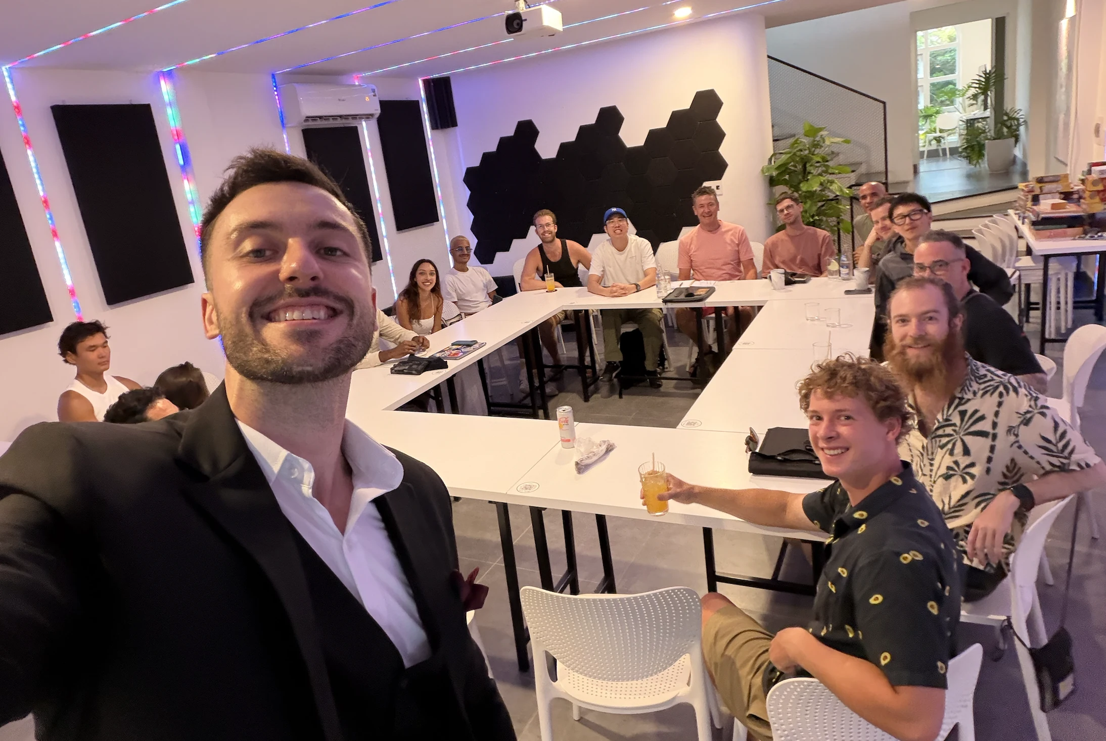 Jake in a suit with participants from a previous content workshop